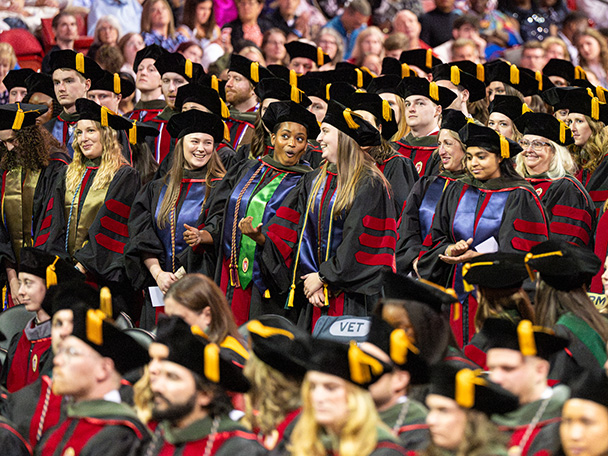 A section of advanced-degree graduates rise during the Commencement ceremony.