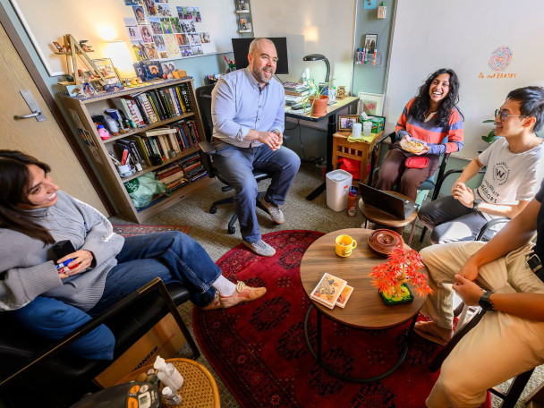 Brendan Eagan meets with a group of undergraduate research interns in a nicely furnished office.