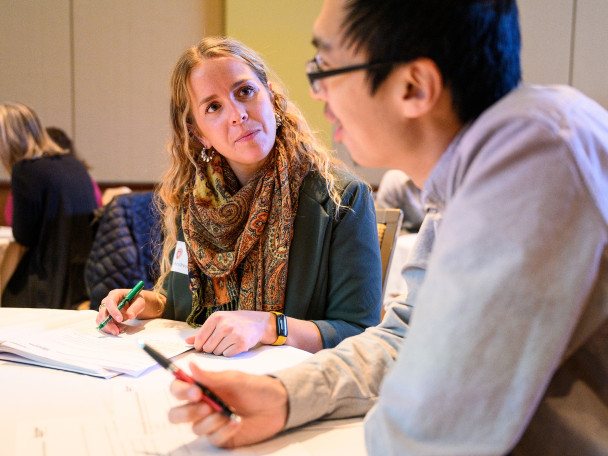 Two workshop participants talking at a table