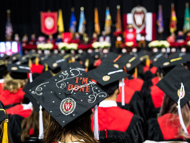 A commencement cap in a sea of others has the phrase "I'm done" and a UW logo on it.