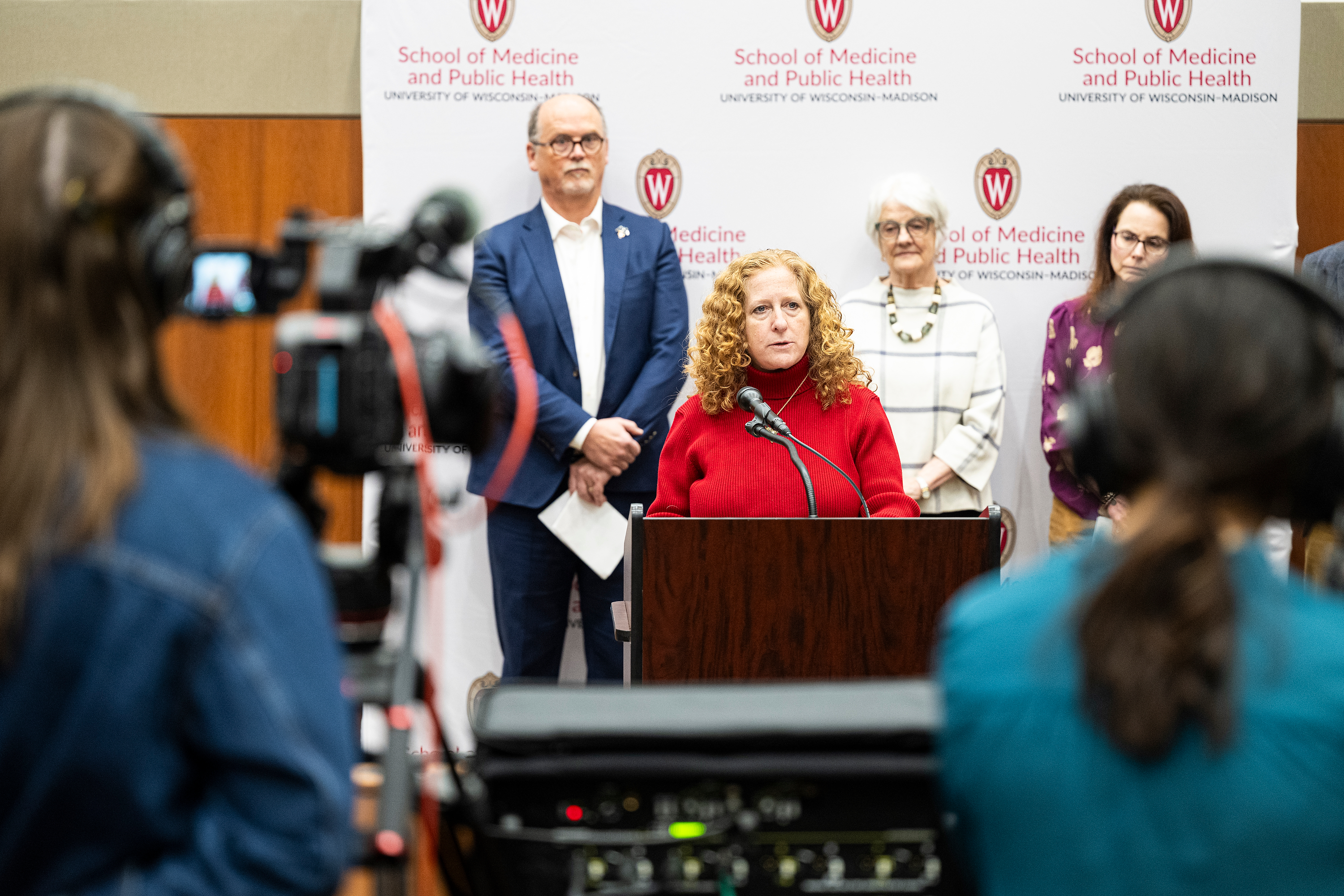 Chancellor Mnookin sands behind a podium addressing media.